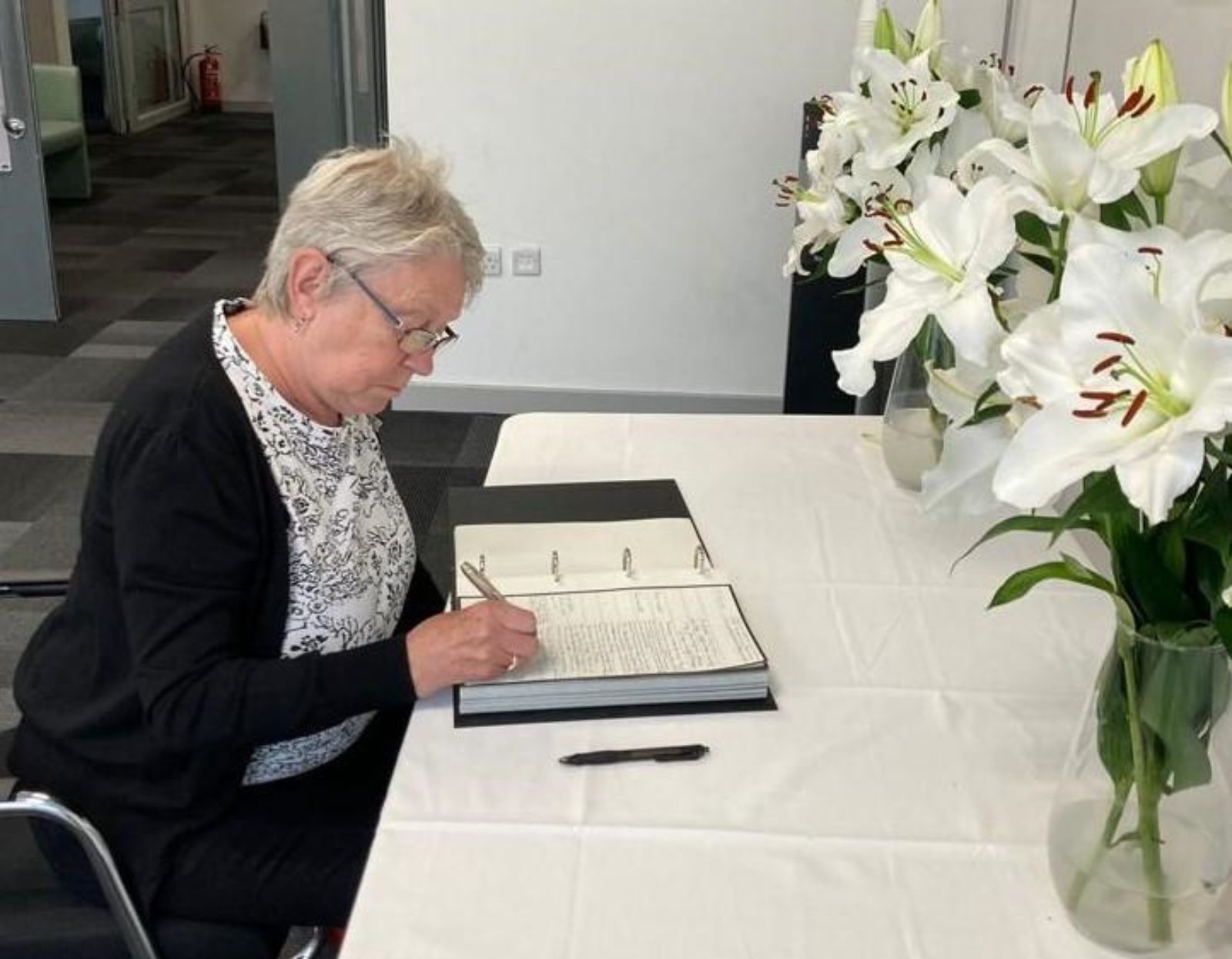 Councillor Sh eila Berry signing the book of condolences in Sutton